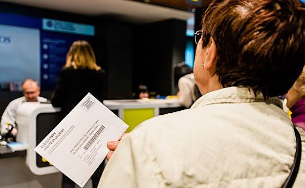 Una ciudadana espera su turno para votar por correo.