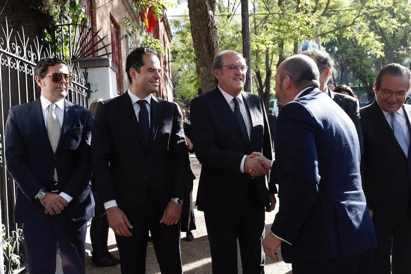 El presidente en funciones de la Comunidad de Madrid, Pedro Rollán (d, de espaldas), saluda al candidato del PSOE-M a la Comunidad de Madrid, Ángel Gabilondo (3i).