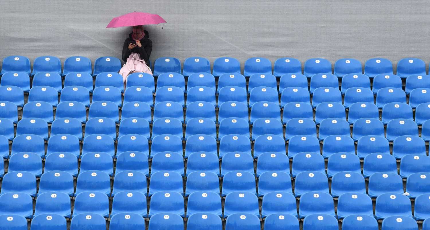 Una espectadora cubierta con un paraguas durante la interrupción del partido debido a la lluvia en el ATP tennis Open en Munich, sur de Alemania