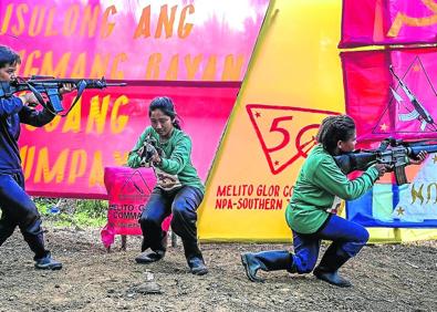 Imagen secundaria 1 - Los camaradas del Nuevo Ejército del Pueblo se ejercitan en la selva filipina.