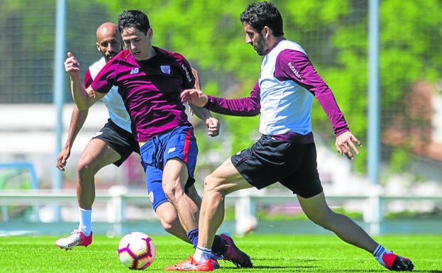 El dinamizador del equipo. Raúl García disputa un balón con Asier Benito, del Bilba Athletic, en el entrenamiento de ayer en Lezama.