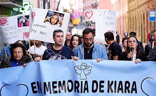 El padre de la niña hallada muerta en Atxuri, cabizbajo en el centro, porta la pancarta, rodeado por sus allegados.