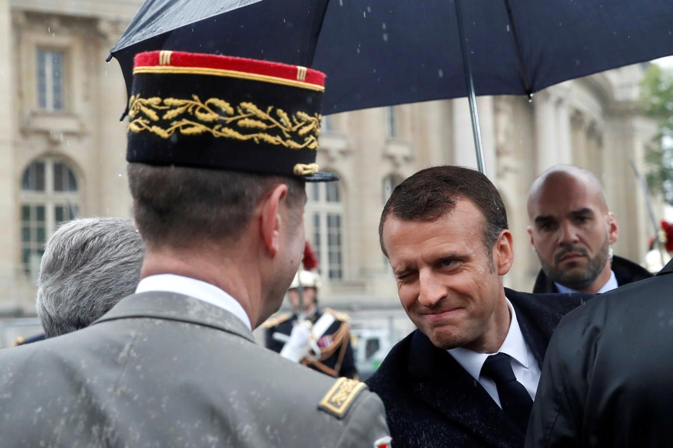 El presidente francés, Emmanuel Macron, sonríe a un oficial militar cuando asiste a una ceremonia en la estatua del general Charles de Gaulle para conmemorar el Día de la Victoria en París, Francia
