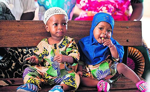 Imagen principal - Arriba, los mellizos Kehinde y Taiwo Akinbola esperan en el hospital de Igbo Ora a recibir sus vacunas. Abajo a la izquierda, Suliat Ogunjimi con sus mellizos Afusat Ganiyu y Ganiyatu Adesope, en la misma localidad nigeriana. A la derecha, Los gemelos idénticos Taiwo Ahmed y Kehinde Ahmed. 