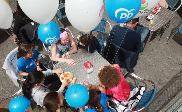 Unos niños con globos del PNV y PP en la plaza de España.