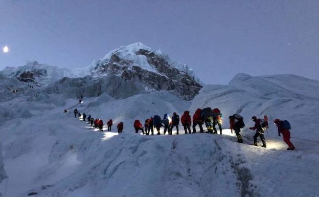 Un grupo de clientes y sherpas asciende camino de los campos de altura.