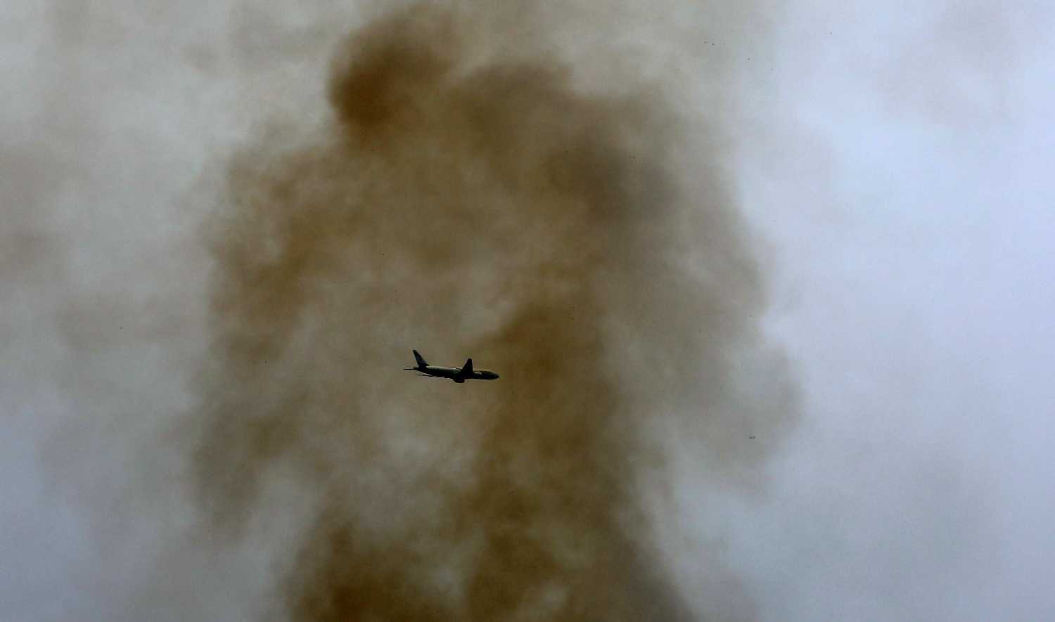 Una avioneta volando sobre una nube de humo en Nablus, Cisjordania, debido a la ola de incendios que se extiende por el país