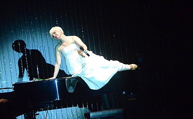 En la segunda parte, con el segundo vestido, cantando sobre el piano de cola. 