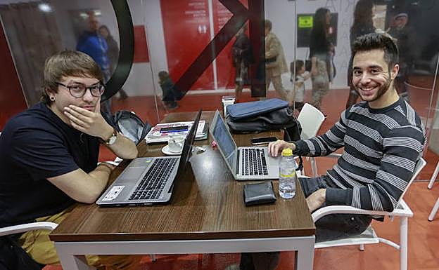 Borja y Carlos preparan su trabajo fin de máster mientras centenares de electorales pasan a unos metros.