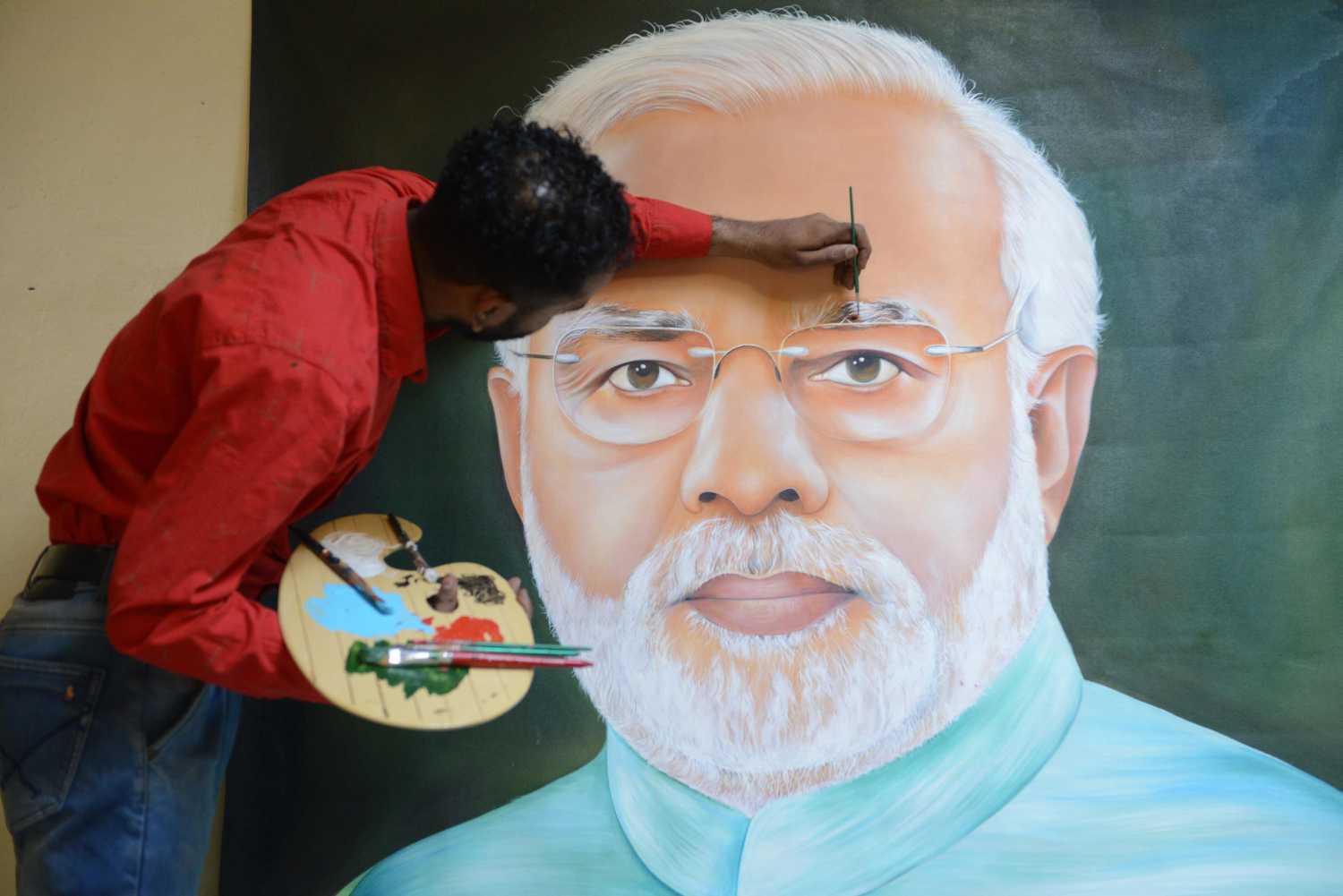 El pintor indio Jagjot Singh Rubal dando los toques finales a una pintura que representa al primer ministro indio Narendra Modi, en Amritsar