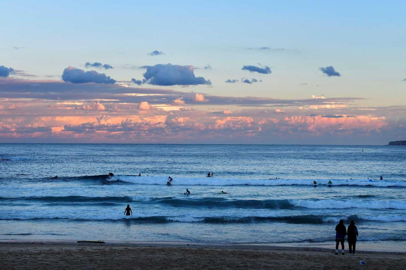 Surfistas al atardecer en la playa Bondi en Sídney (Australia