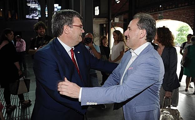 El Alcalde de Bilbao , Juan maría Aburto y el Portavoz del PSE Alfonso Gil , se estrechan la mano en el Azkuna Centroa , durante un concierto por el aniversario de la caida de Bilbao