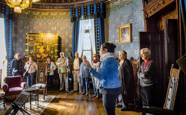 Varios visitantes atienden las explicaciones de la guía en una de las salas del hogar de Antoine d'Abbadie.