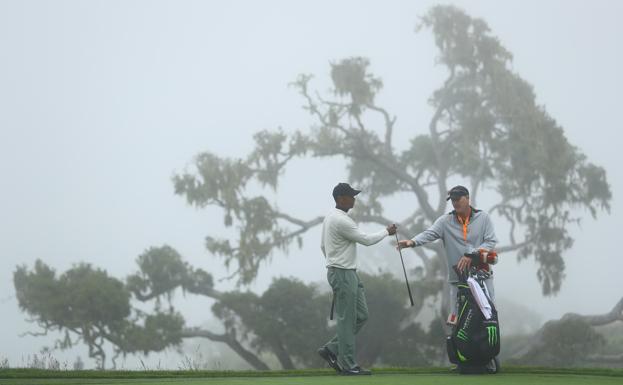 Tiger Woods y su caddie Joe LaCava en el green del 14 mientras la bruma ganaba terreno ayer por la mañana en Pebble Beach. 