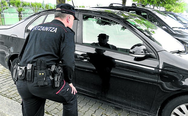 Jesús observa el interior de un coche aparcado para comprobar si ha sido forzado.