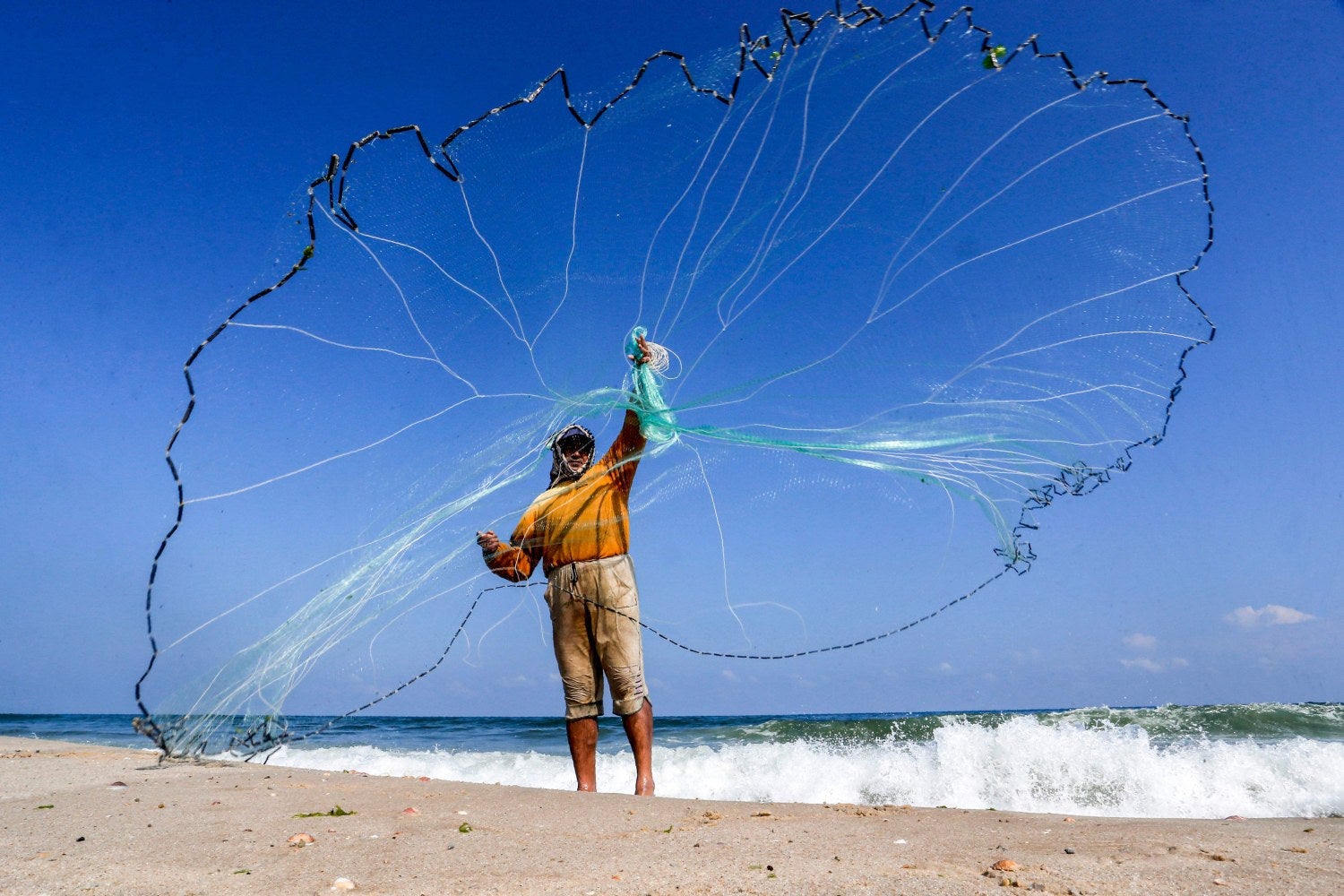 Un pescador palestino lanza su red en la playa de Khan Yunis, en el sur de la Franja de Gaza. El gobierno israelí dijo a fines del 12 de junio que la zona de pesca frente a la costa de Gaza había sido cerrada, en represalia por el lanzamiento de globos incendiarios desde el enclave palestino. La medida se produjo después de que COGAT dijera el martes que había reducido la extensión de la zona de pesca a seis millas náuticas desde las 10 millas náuticas, habiendo bajado la escala de 15 millas náuticas hace una semana. 