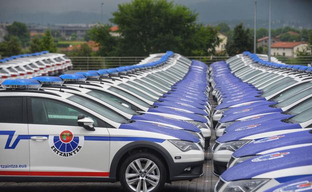 Agente de la ertzaintza intenta entrar en uno de los nuevos coches patrulla, que han pedido retirar ya que no tienen espacio para los agentes