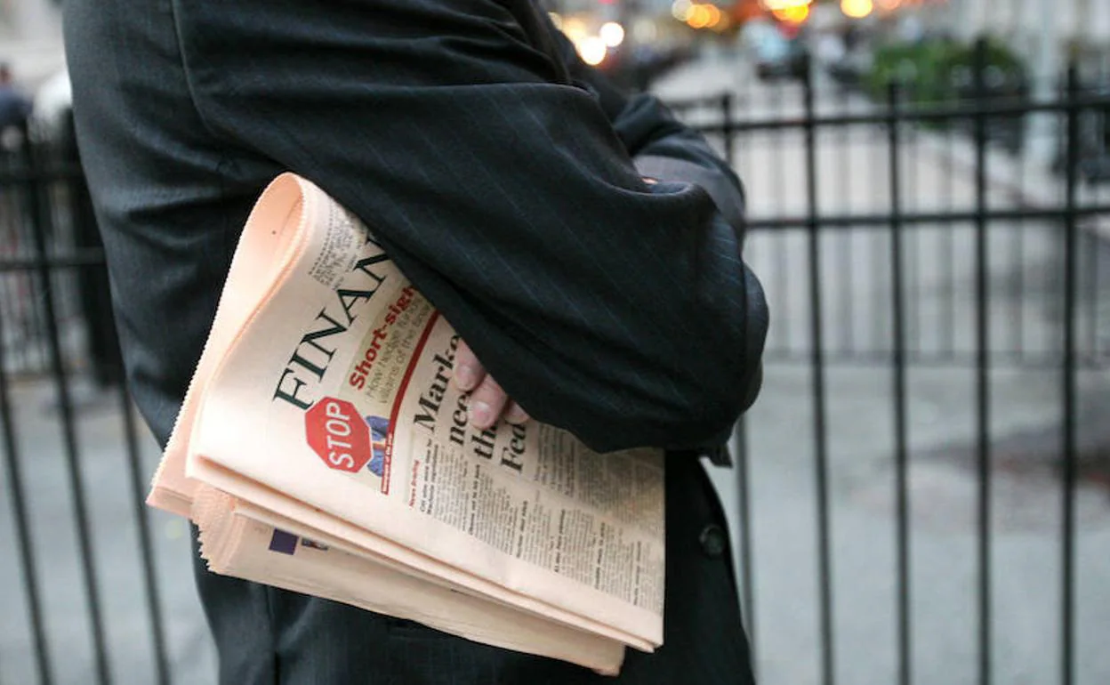 Un hombre sostiene un ejemplar del Financial Times.