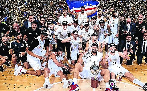 La plantilla y el cuerpo técnico del Real Madrid celebran sobre el parqué del Palau y bajo una lluvia de confeti el título liguero. 