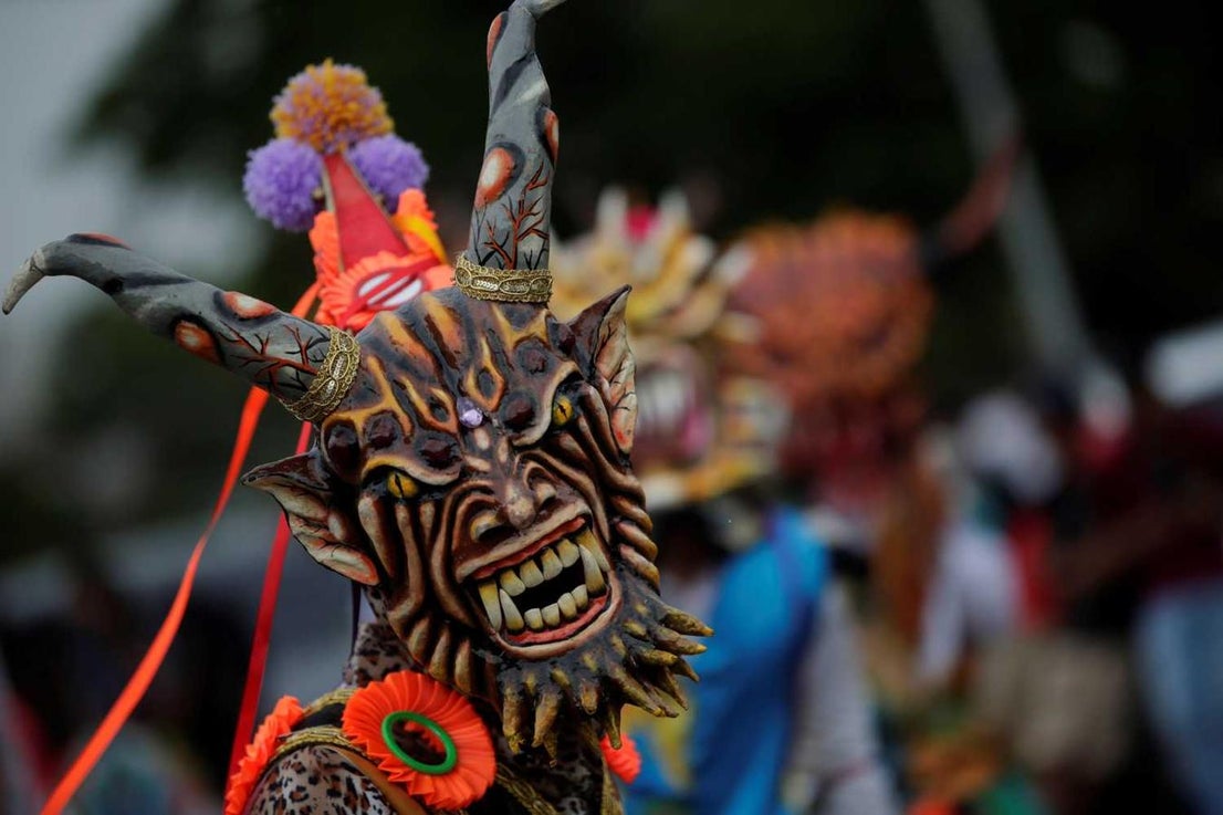 Un hombre vestido de diablo baila por la calles de La Chorrera en celebración al Corpus Christi, en Panamá