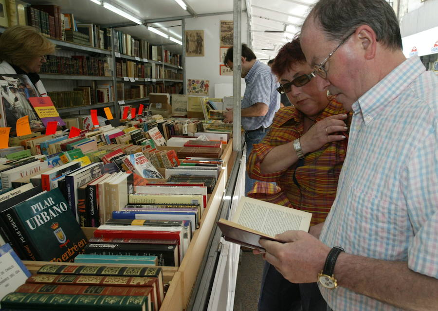 Vitorianos ojean ejemplares de la Feria del Libro Antiguo y Viejo.