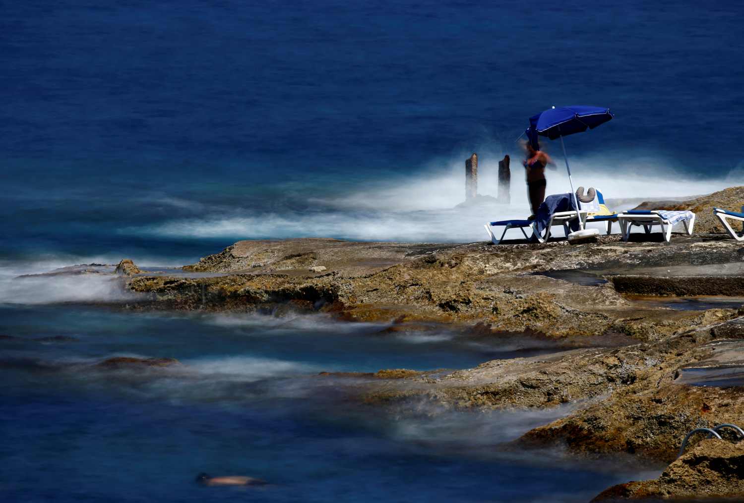 Bañistas se refrescan en una playa rocosa en Sliema, Malta.