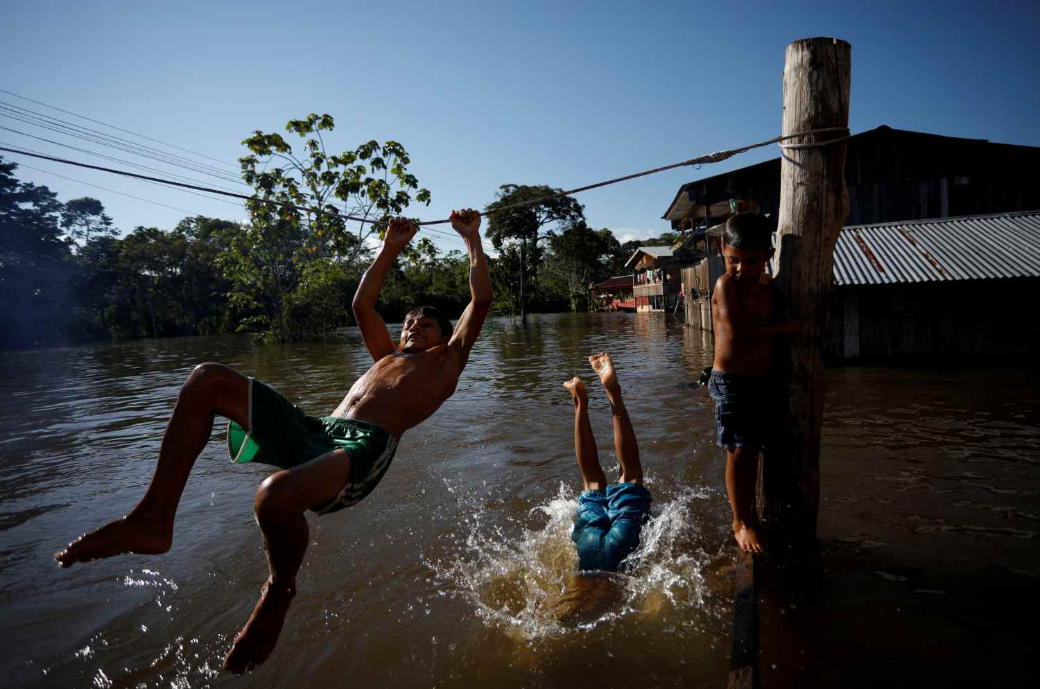 Niños juegan en una calle inundada por la crecida del Río Solimoes, una de las dos afluentes principales del río Amazonas, en Anama, estado de Amazonas, Brasil