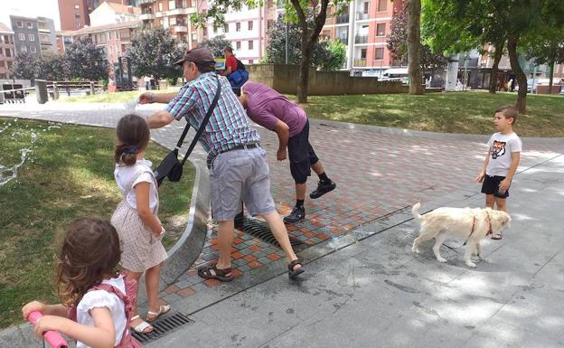 Mucha gente se refrescaba en la fuente de la plaza Solabarria.