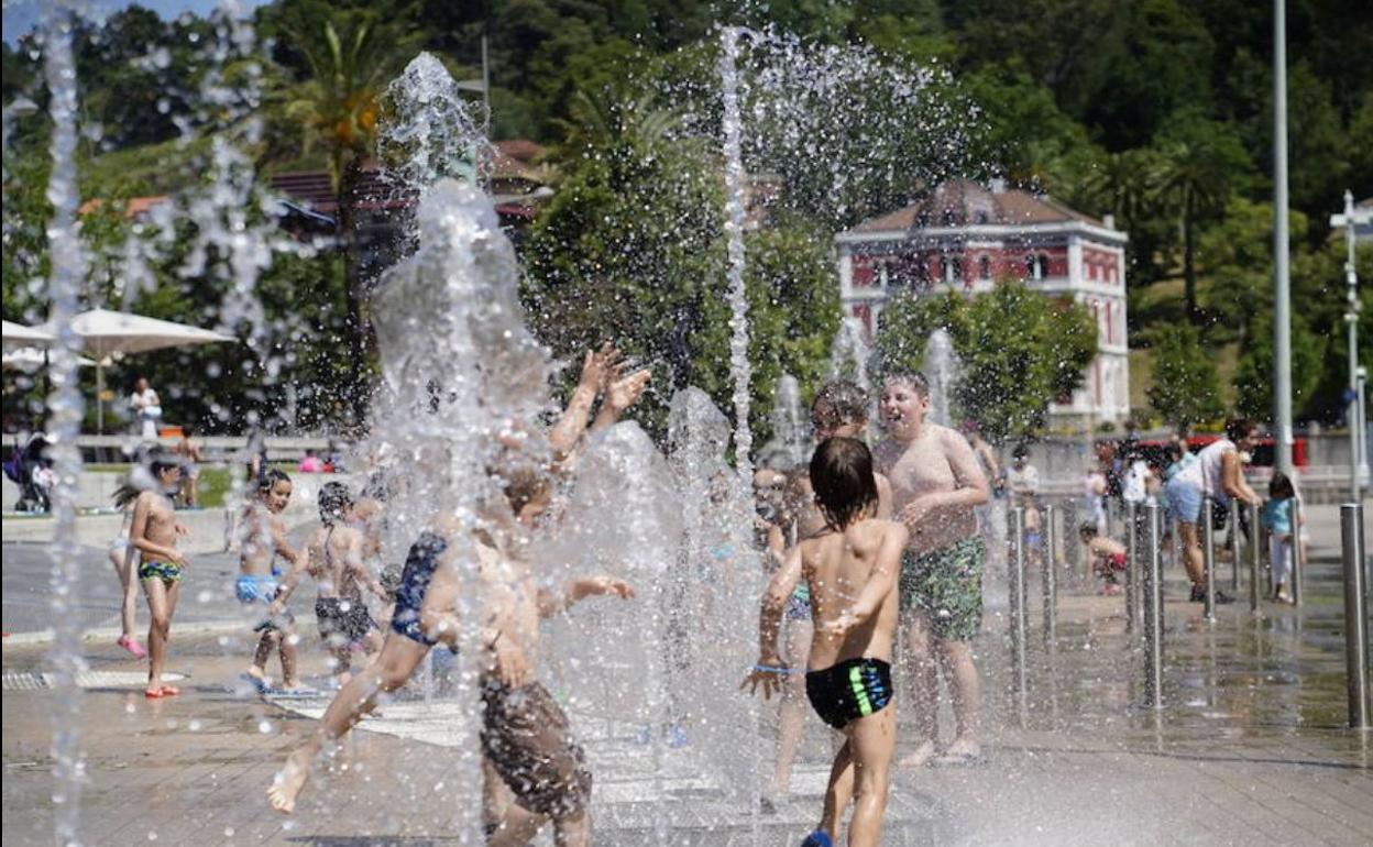 Niños se refrescan en chorros de agua para aliviar el calor