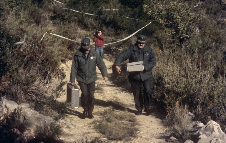 Dos antropólogos forenses examinan cuatro pequeños huesos para determinar si pertenecen a una de las niñas asesinadas en 1992