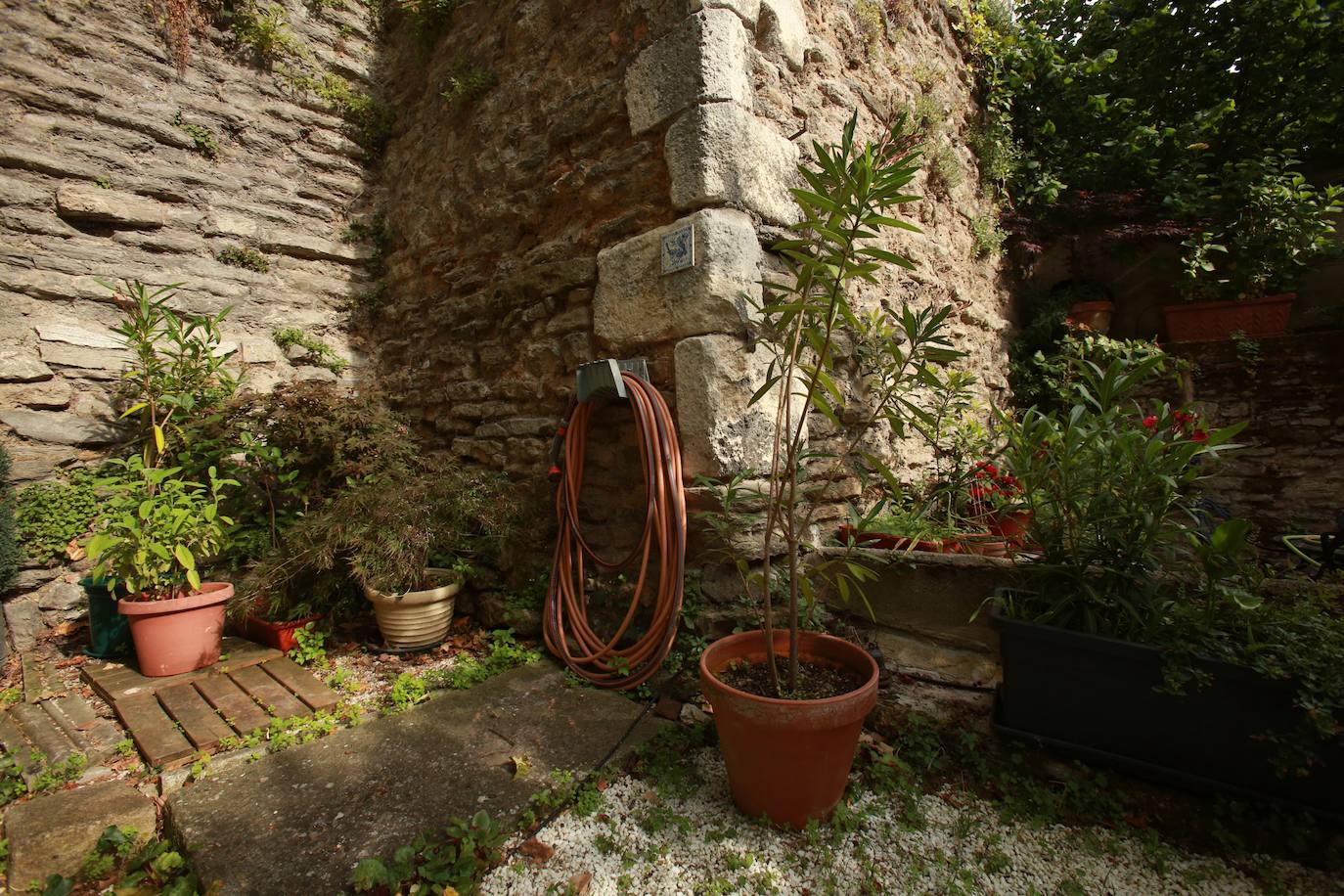Suelo con piedras antiguas y de fondo la muralla de la ciudad en el rincón de Ana Isabel