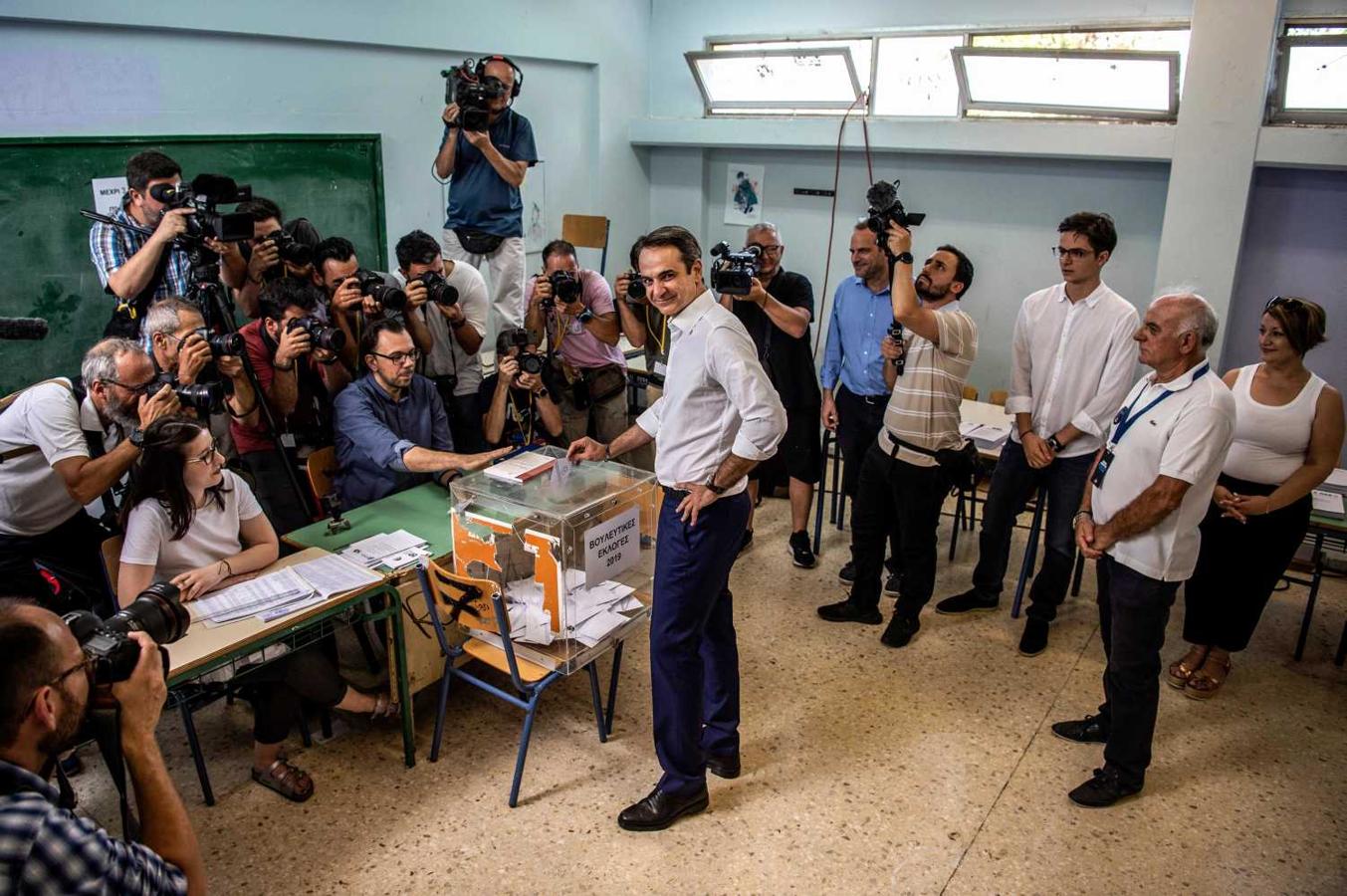 El líder del partido, Nueva Democracia, Kyriakos Mitsotakis (C), emite su voto durante las elecciones generales en una mesa electoral en Atenas 