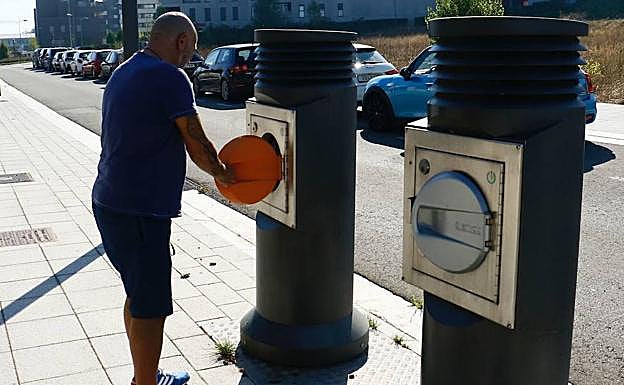 Un hombre abre la tapa de uno de los buzones de recogida neumática en la calle Félix González Petite, en Aretxabaleta. 