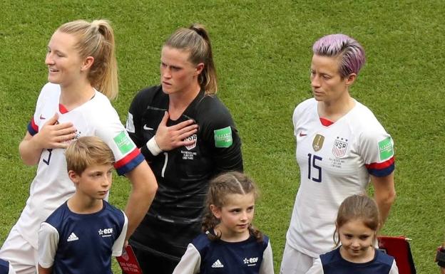 Imagen principal - Arriba, Rapinoe protestando sin cantar el himno de su país. Abajo, la brasileña Marta Vieira con botas negras y un signo de 'igual', al lado de Ada Hegerberg, la gran ausente.