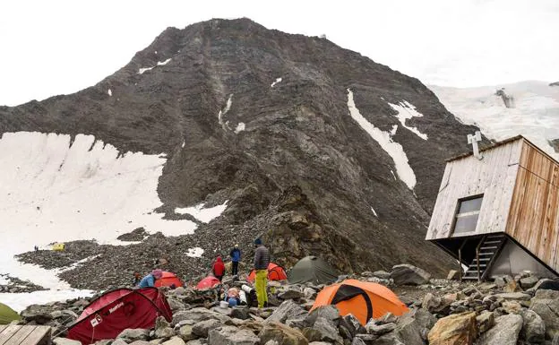 Alpinistas acampan junto a refugio de Gouter en un paisaje sin apenas nieve.