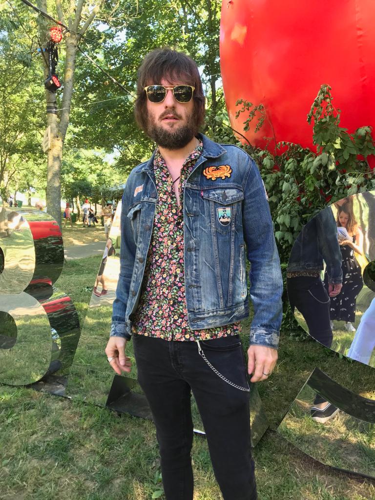 Iñaki Estevez, de 44 años, es guitarrista del grupo de rock Olimpia. Es su décima vez en el BBK Live, así que es un veterano de Kobetamendi. Lleva una camisa de flores con un dragón chino bordado, de River Island, y una cazadora vaquera de Levi´s customizada por él. "Todo el año voy con este look. Duermo con él", bromea.