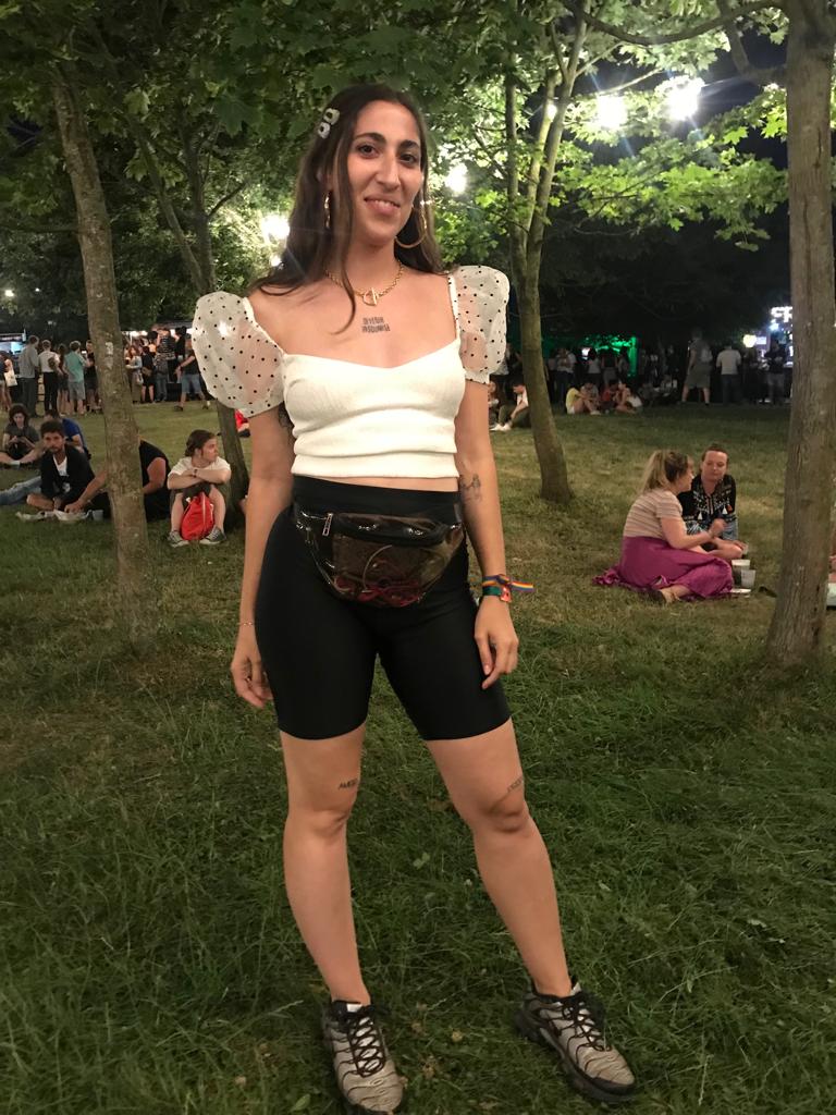 Ana Panizo, madrileña de 23 años, lleva una camiseta de Zara con mangas abullonadas de plumeti y unas mallas de Bershka. Como accesorios, ha elegido una riñonera, el bolso estrella de este festival, unos aros XL dorados y unas horquiillas nacaradas.