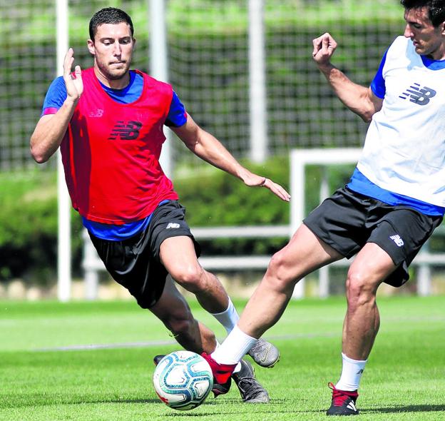 De Marcos persigue el balón que controla Vivian en el entrenamiento de ayer en Lezama. 