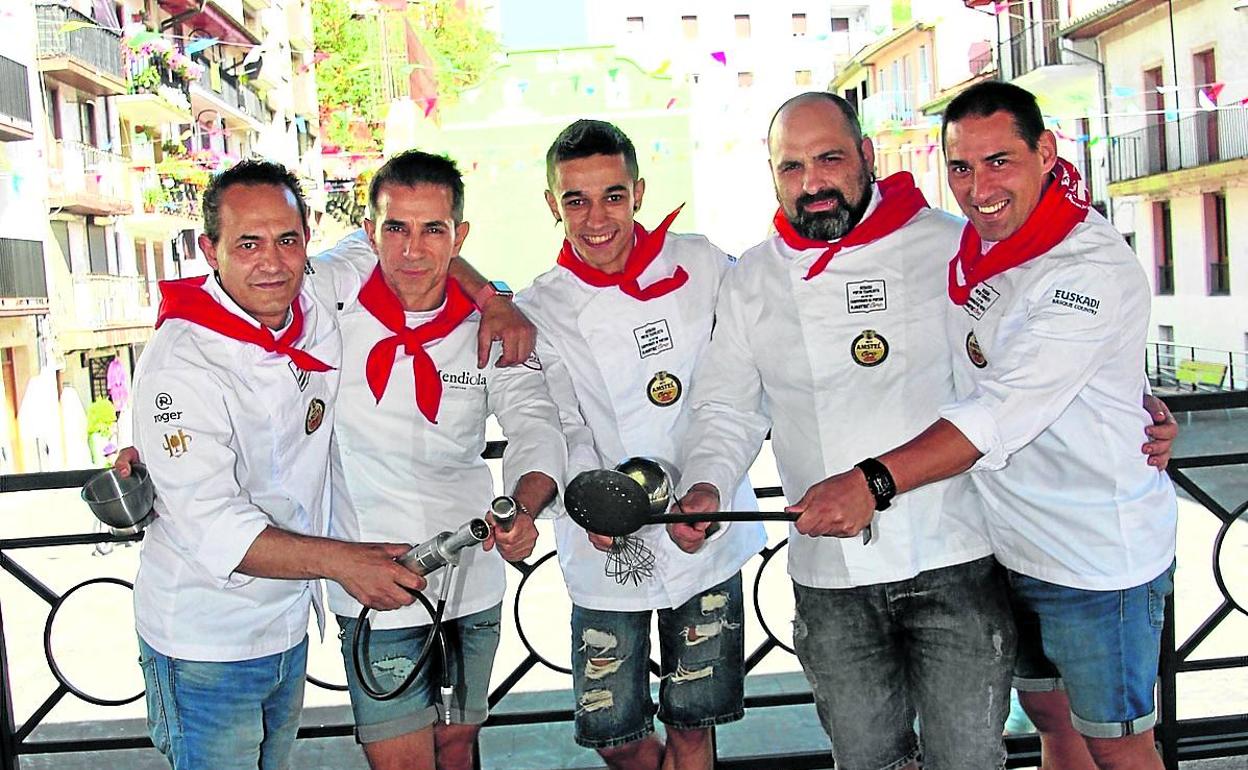 Los cinco cocineros posan con sus instrumentos de trabajo en el quiosco de la plaza. 