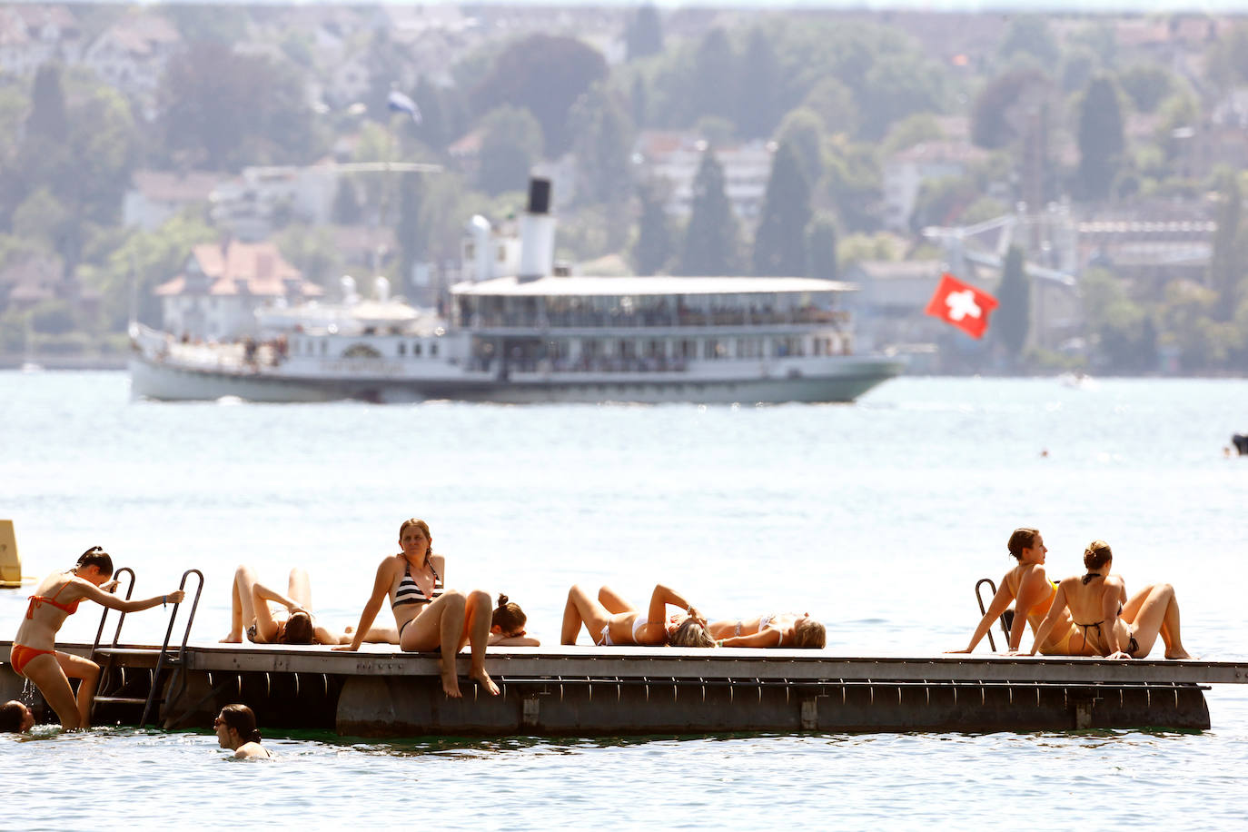 Turistas se relajan en uno de los muelles del Lago Zurich, en Suiza