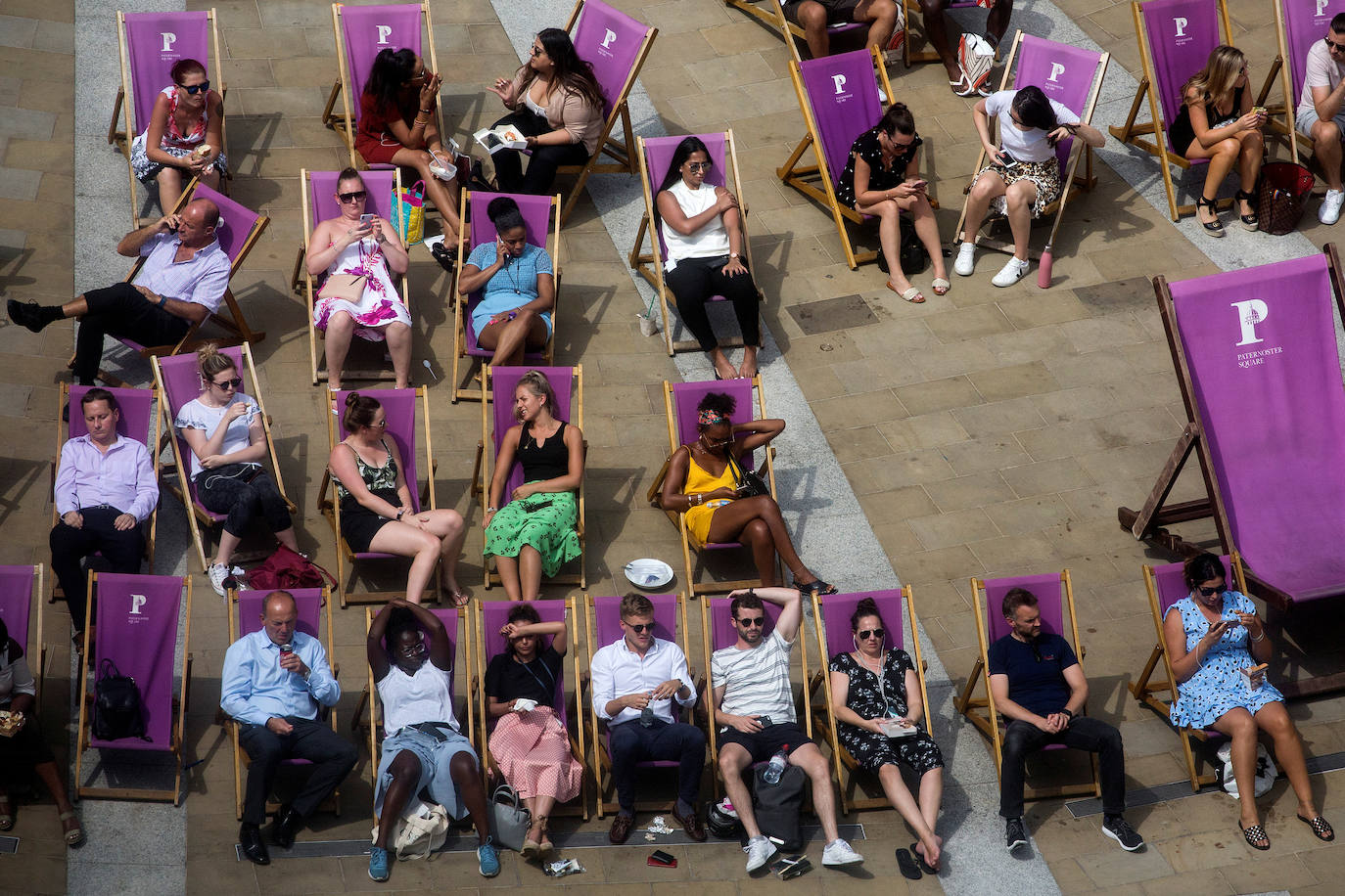 Trabajadores descansan en sillas durante su hora de comida en Londres, Reino Unido