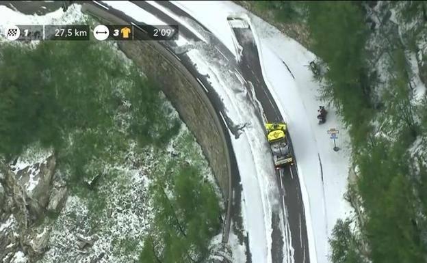 Un quitanieves trata de apartar la capa de granizo que ha caído en la etapa de este viernes del Tour de Francia.