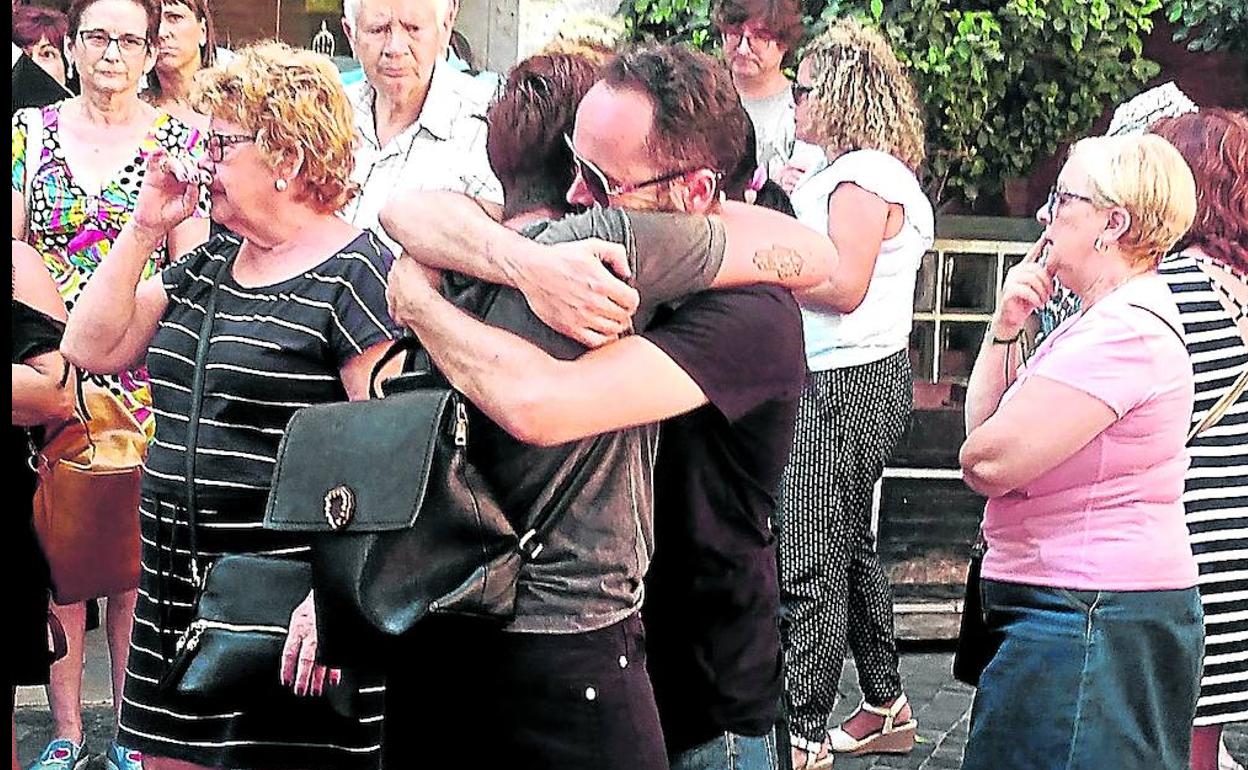 La madre del niño asesinada es consolada por sus familiares y vecinos durante la concentración.