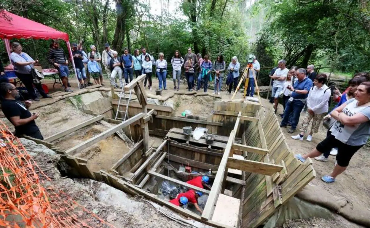 Un grupo personas observa el yacimiento de Aranbaltza. 