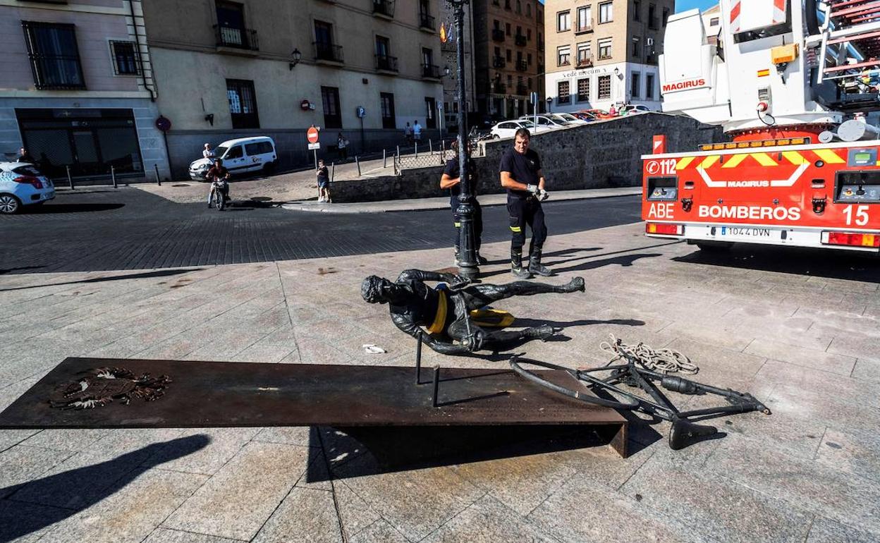 Bomberos proceden a retirar la escultura.