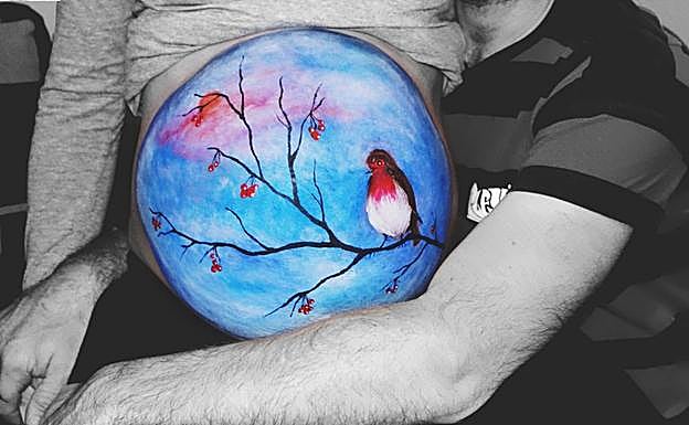 Paisaje de invierno, un diseño artístico realizado en el último mes de embarazo. «El bebé nacía en invierno y la madre y el padre eligieron este diseño. Las nubes están trabajadas con pintura de base grasa para crear un efecto cielo perfectamente difuminado. El sol del atardecer, con pintura al agua de textura en polvo. En la mano del padre dibujé unas carpas de color naranja». 