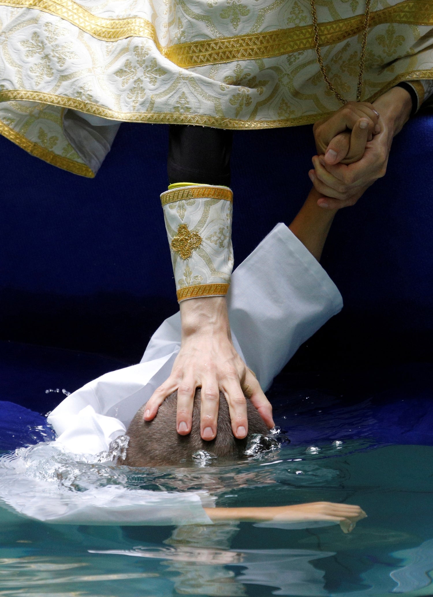 Un sacerdote ortodoxo bautiza a un niño durante una ceremonia de bautismo en masa para conmemorar el aniversario de la cristianización del país, que en ese entonces se conocía como Kievan Rus, en Stavropol, Rusia.