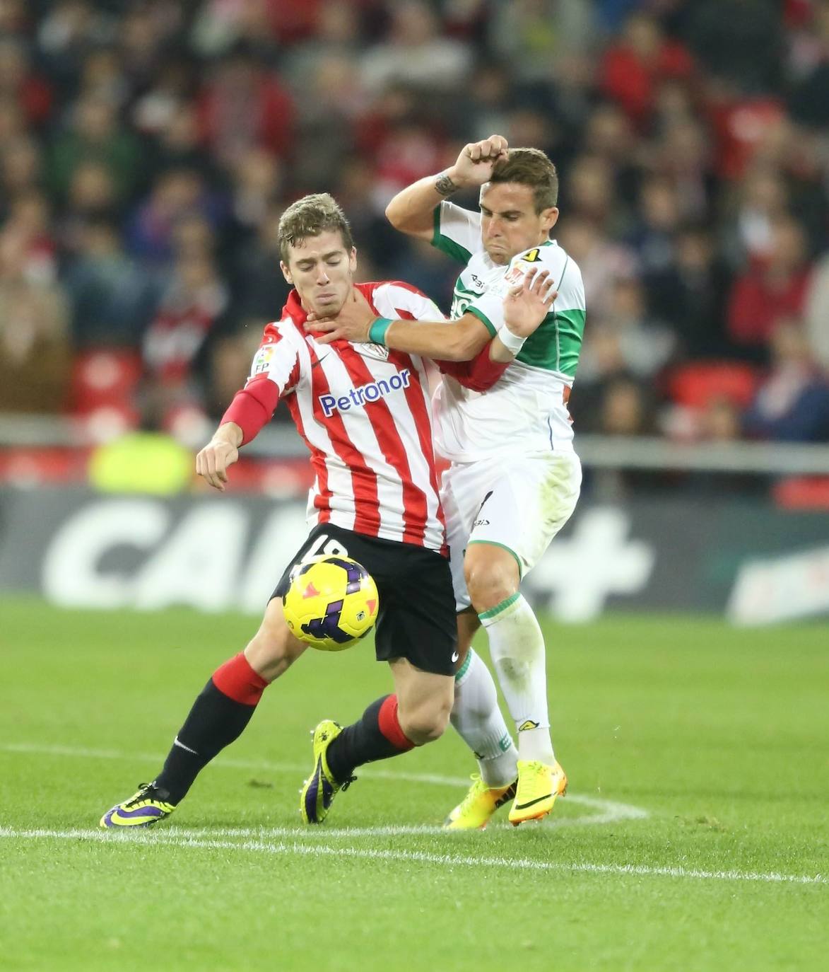 Muniain trata de mantener el balón en un cuerpo a cuerpo con un jugador rival, en 2005.