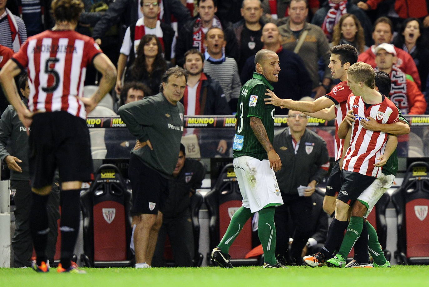Susaeta media entre Muniain y un jugador rival durante una partido.