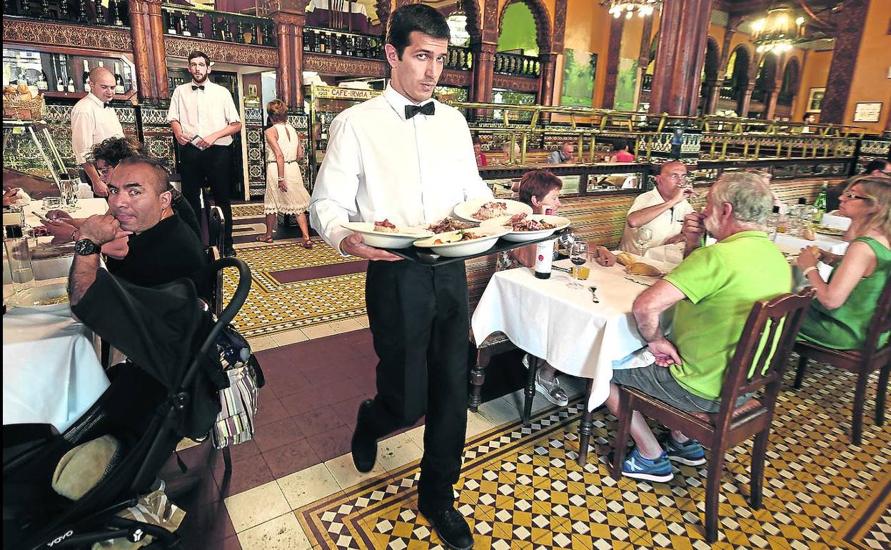 Un camarero atiende las mesas del Café Iruña en Bilbao, donde «casi todos» sus 19 compañeros «son veteranos».